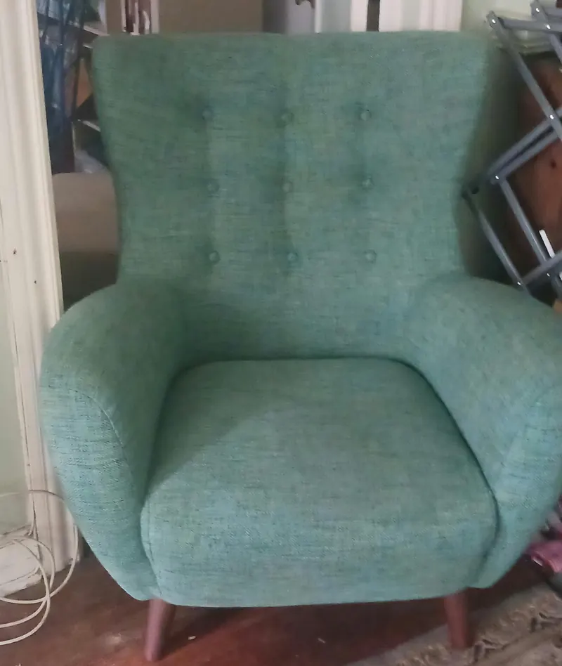 A teal button tufted fabric armchair